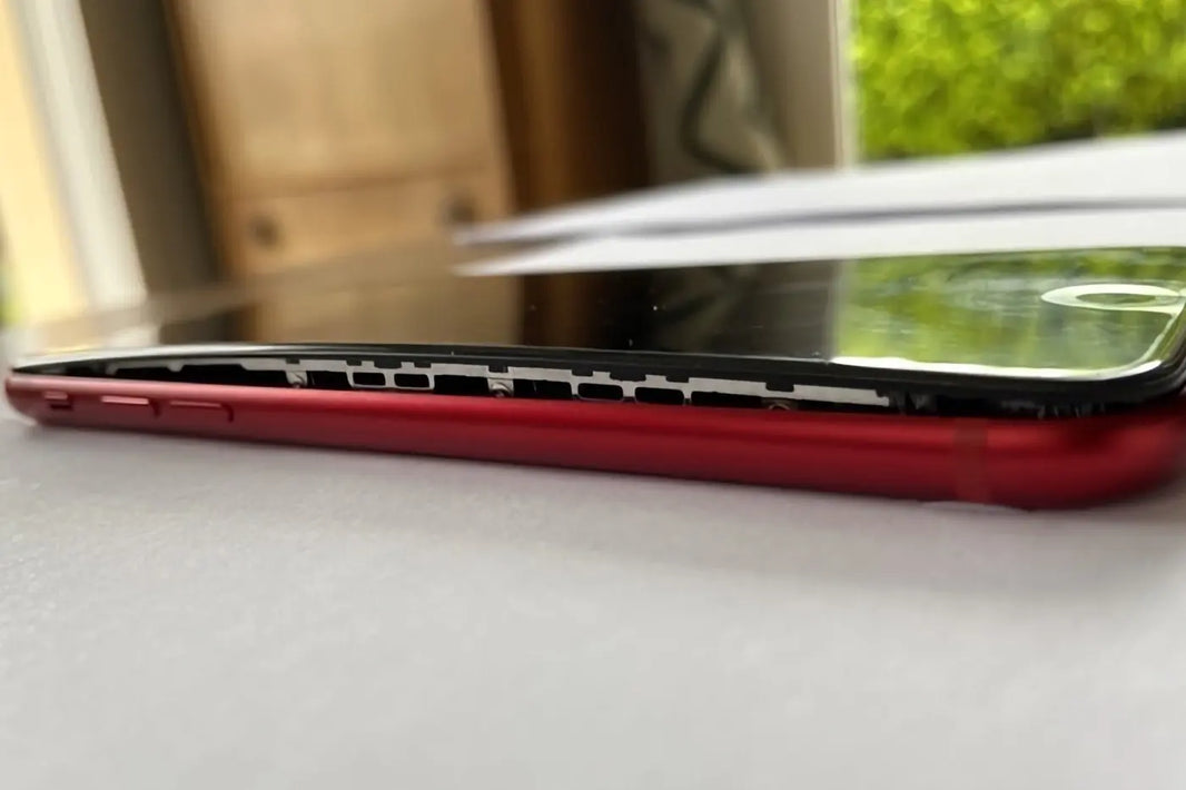 Batterie de smartphone gonflée faisant décoller l’écran, signe d’usure nécessitant une réparation rapide chez iTelier Lyon