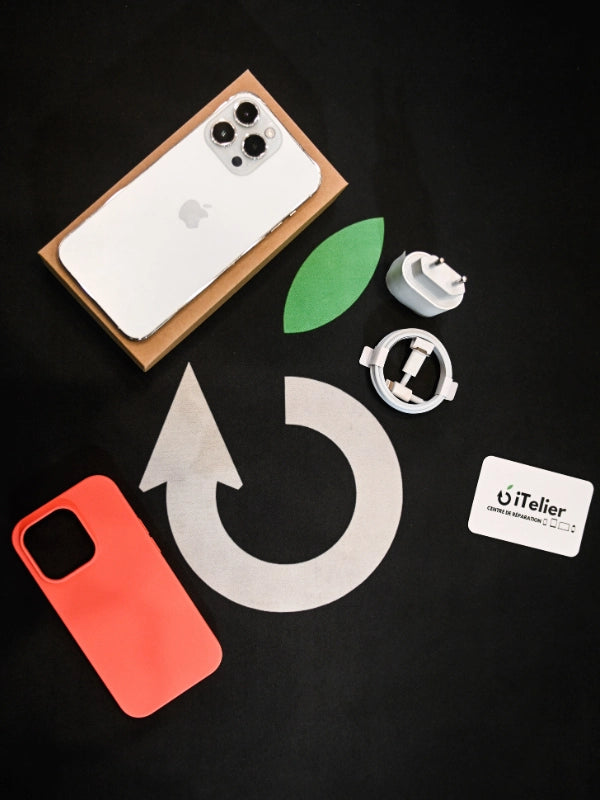 Accessoires essentiels pour smartphone posés sur une table en bois : chargeur secteur, câble de recharge, station de charge sans fil, batterie externe et téléphone.