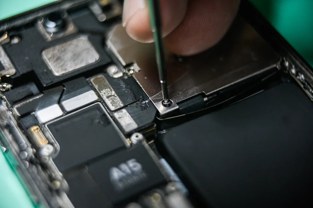 Technicien iTelier intervenant sur un smartphone pour une réparation de précision, garantissant fiabilité et performance à Lyon.